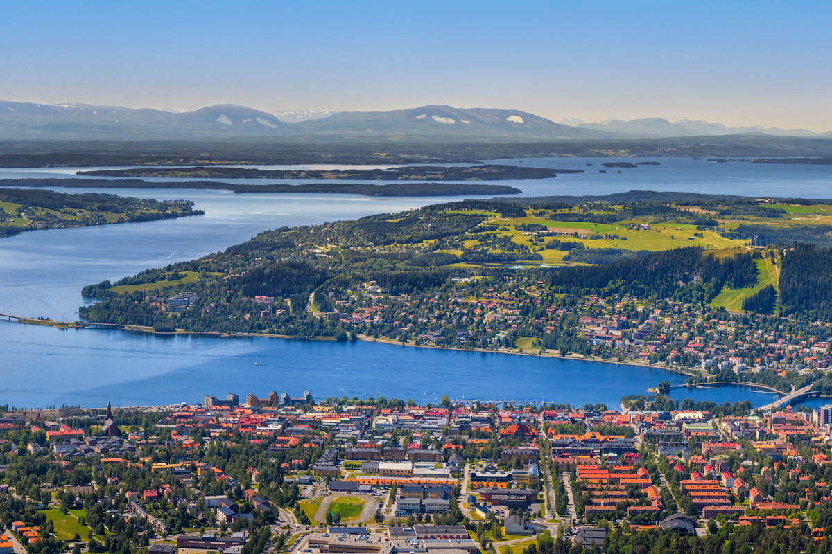 Bild över stad, fjäll och sjö