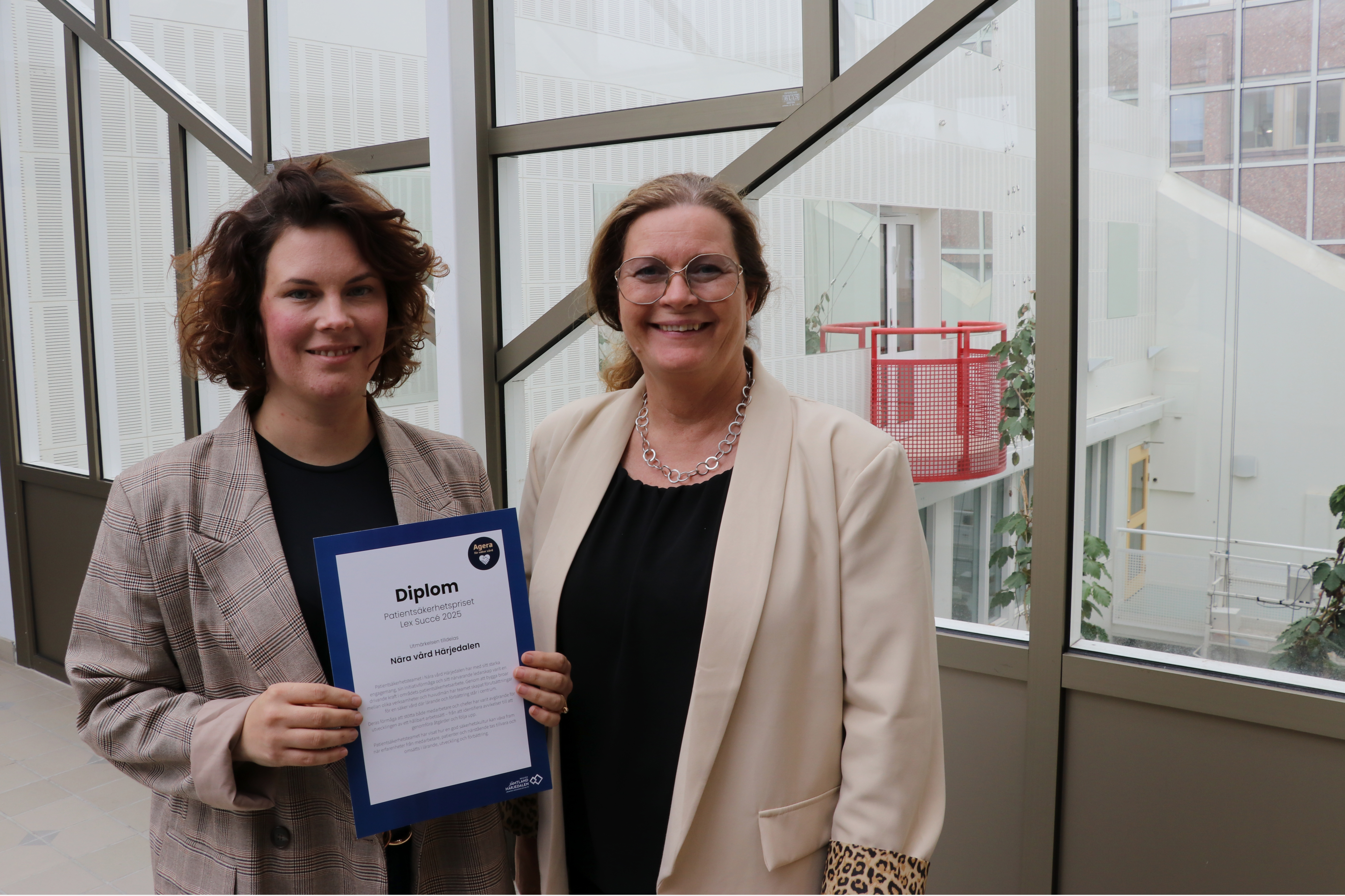 Maria Långström och Anna Fremner står bredvid varandra. Maria håller i ett diplom. Båda är glada.