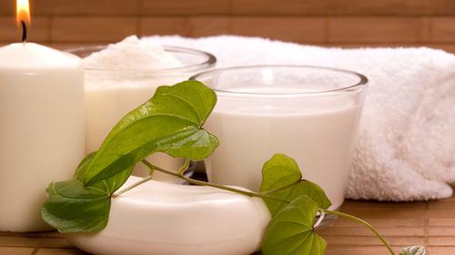 Ett tänt ljus, tvål, handduk och två glas mjölk.