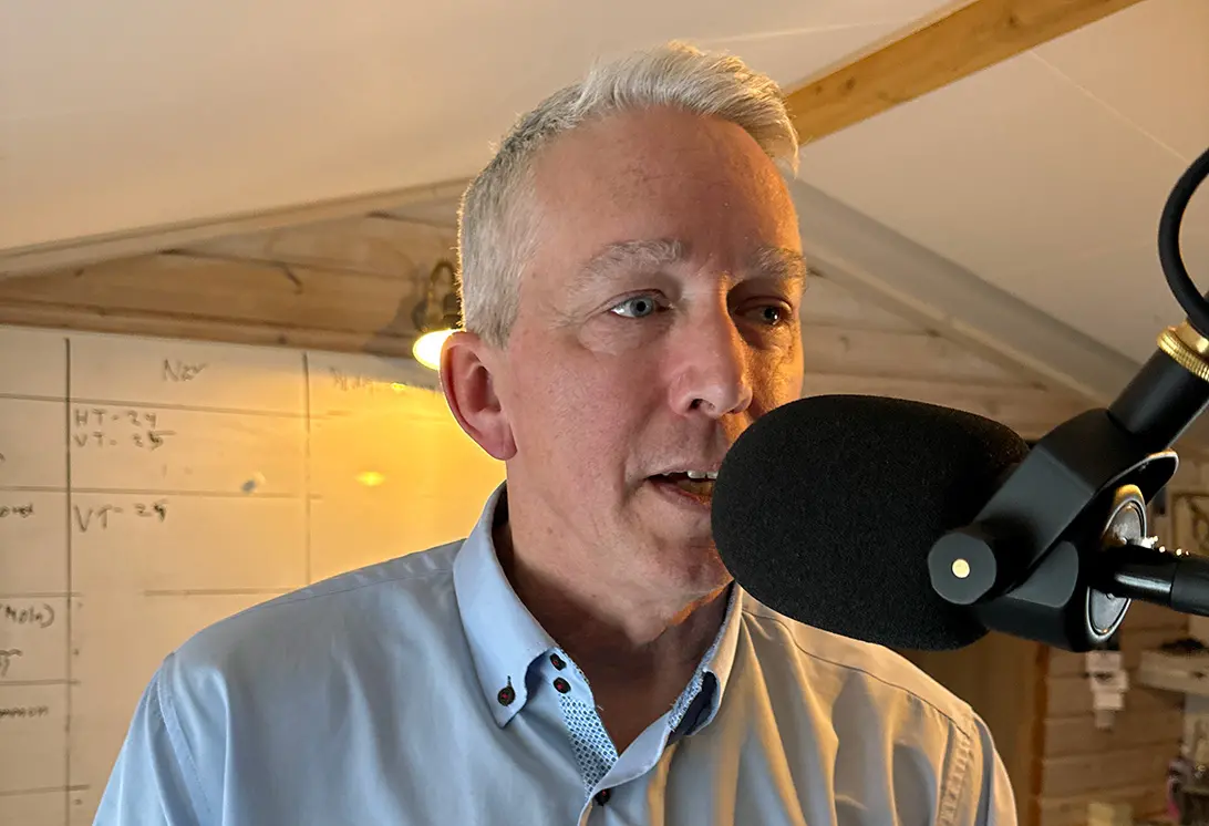 Närbild på man med kort hår som talar i en mikrofon