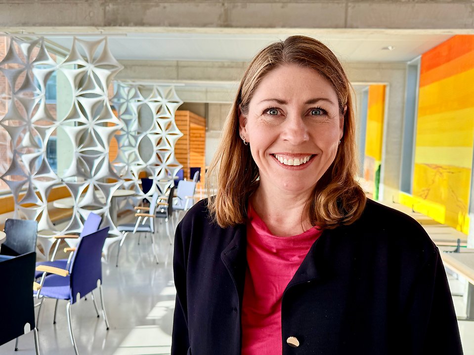 En leende kvinna tittar in i kameran.