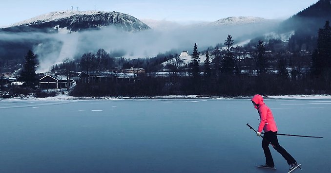 en kvinna åker långfärdsskridskor på en sjö