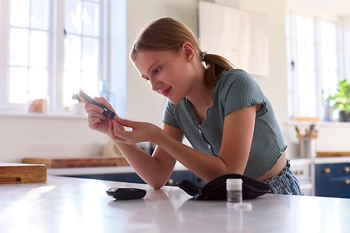 En flicka som testar sitt blodsocker.